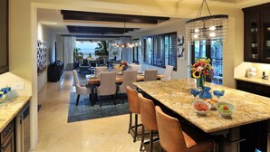 A spacious kitchen with granite countertops, a central island, and a dining area with chairs and tables. - 3rd Night Free-Luxury Oceanview HBC Resort Residence-Medano Beach (Cabo San Lucas)