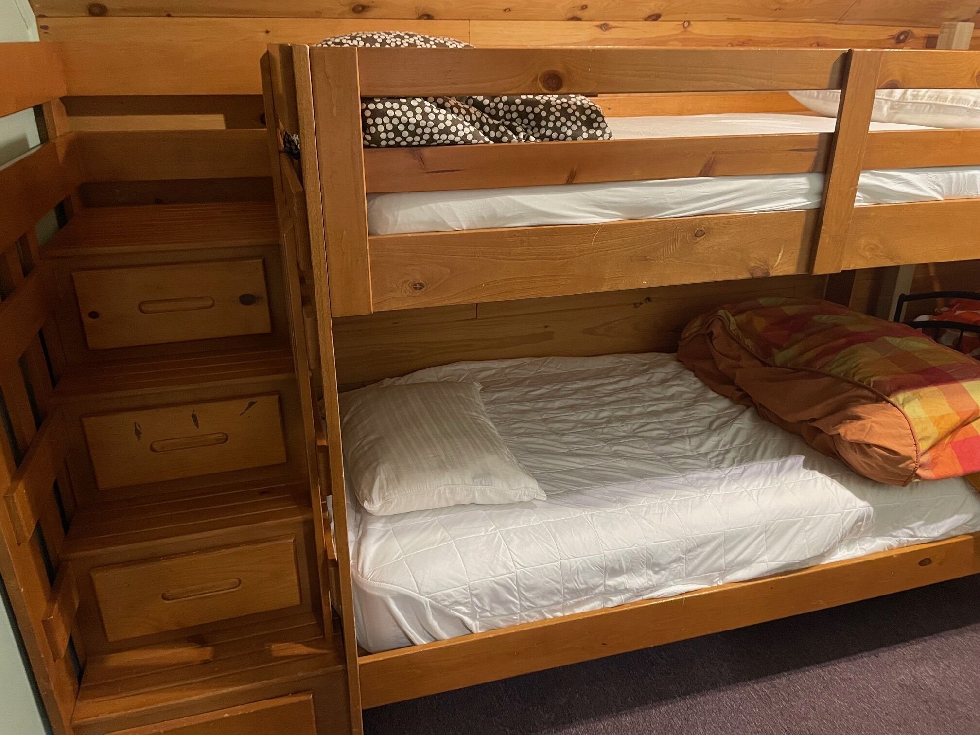 Un lit superposé avec un lit inférieur et un tiroir de rangement en dessous.
