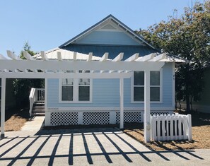 A small, single-story house with a blue exterior and a white porch. - The Good Life - 100+ Top Ratings, Big Pool, Porch, 5 Min Walk to Beach, 4 Bikes (Seacrest Beach)