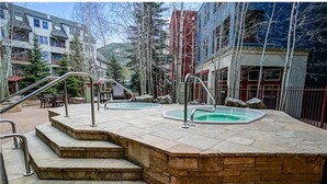 A pool area with steps leading to it, surrounded by stone walls and a metal railing. - Outstanding 2BR in River Run. Fully stocked, steps from gondola and shopping (Dillon)