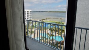A view from a balcony overlooking a swimming pool, a tennis court, and a body of water with boats. - Oh what a view - 711A !!!! (Gulf Shores)