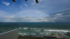 Un balcone con vista sull'oceano e un arcobaleno.