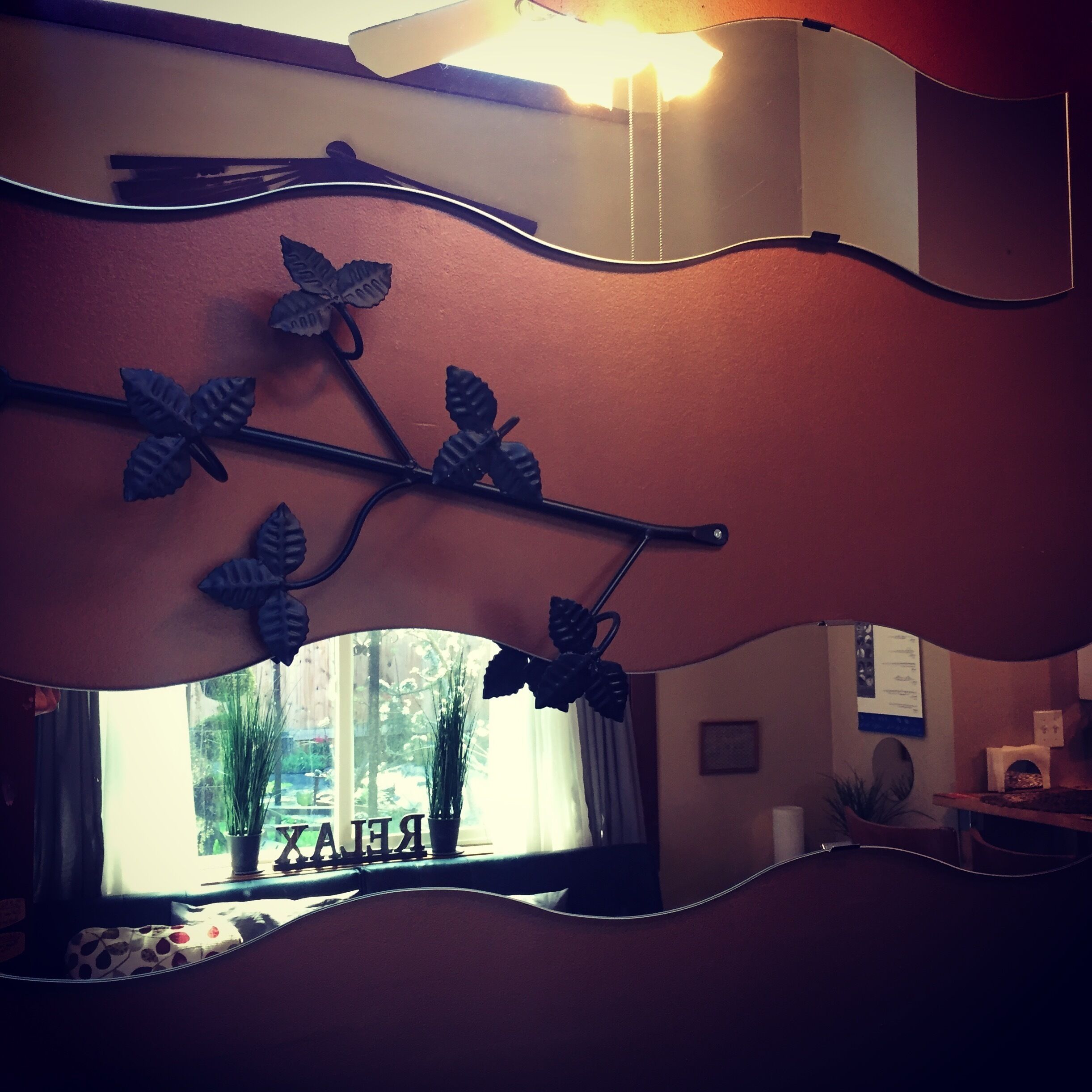 A room with a curved wall-mounted decoration featuring leaves and branches.