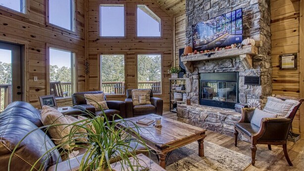 A cozy cabin interior with a stone fireplace, leather sofas, and large windows. - ✨ Chesnut Ridge, Beautiful Mountain Cabin in the Best Location 🏅  (Gatlinburg)