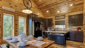 A wooden cabin interior with a kitchen, dining table, and a 'WELCOME' sign. - ✨ Chesnut Ridge, Beautiful Mountain Cabin in the Best Location 🏅  (Gatlinburg)