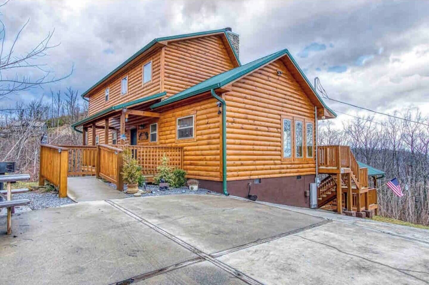 A log cabin with a porch, a covered staircase, and a flag.