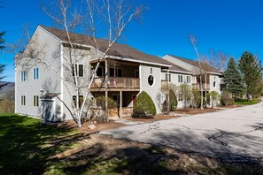 Une maison à deux étages avec un balcon, une véranda et une allée.