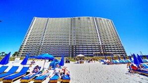 Un hotel grande con varios pisos y una zona de playa al frente.