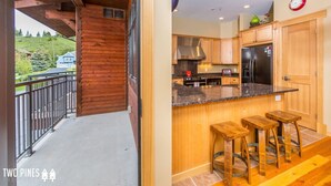 Una cocina moderna con armarios de madera, un refrigerador negro y una encimera de granito.