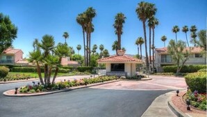 A residential area with palm trees, a central gazebo, and houses with red-tiled roofs. - South Palm Springs Condo - Fantastic Mountain Views! (Palm Springs)