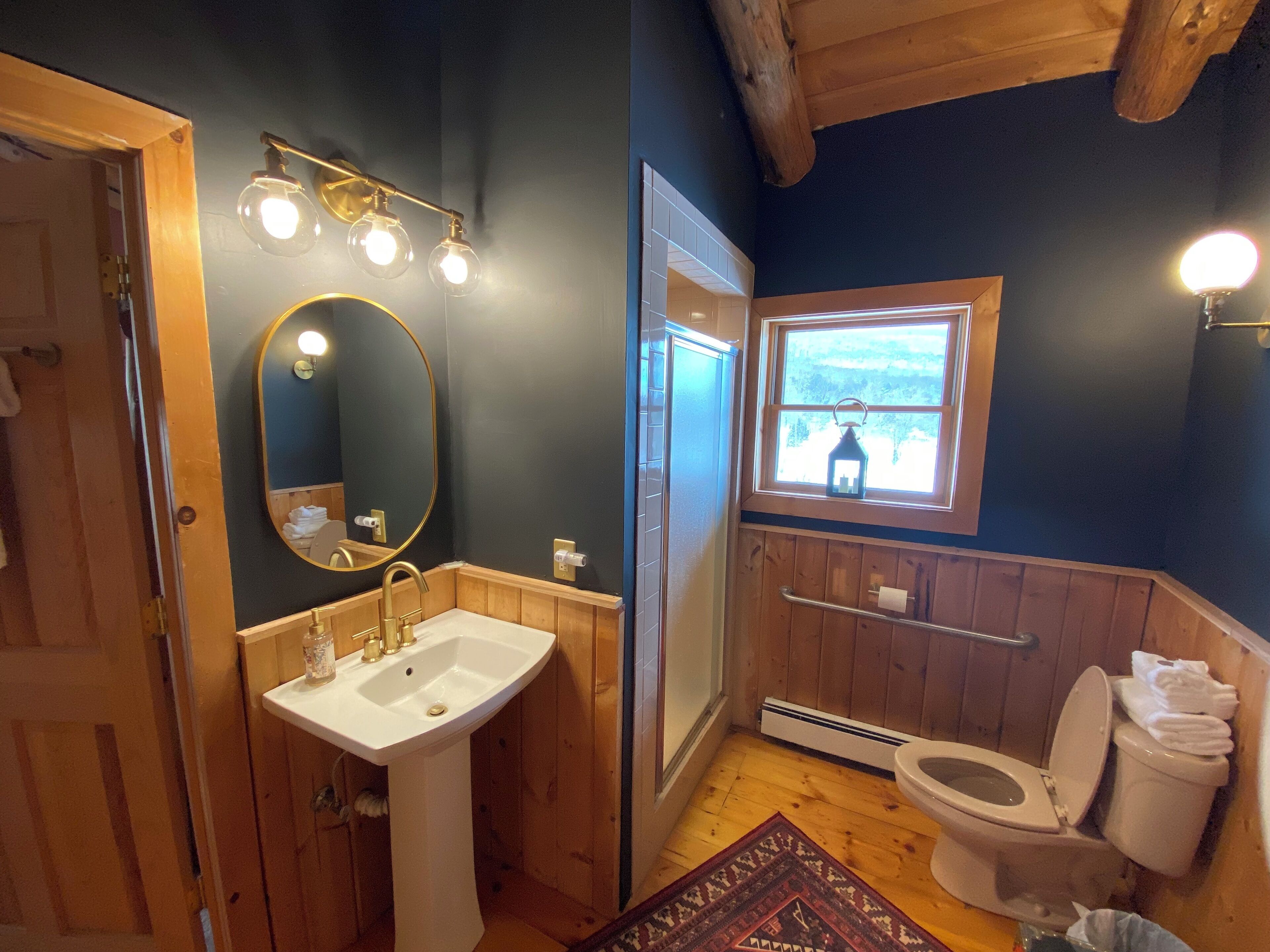 A bathroom with a white sink, a mirror, and a toilet.