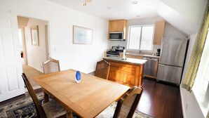 A compact kitchen with wooden cabinets, a microwave, a stove, and a refrigerator. - Charming 1870 Farmhouse in the Heart of Petaluma
 (Petaluma)