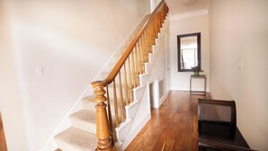 A staircase with wooden balusters, a small table with a plant, and a chair. - Charming 1870 Farmhouse in the Heart of Petaluma
 (Petaluma)