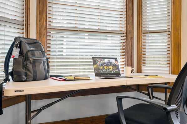 A desk with a laptop, a backpack, and a notebook. - Walk to ND and Eddy Street, ProCleaned * Comfy * Updated (South Bend)