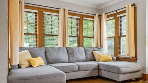 A sectional sofa with a wooden floor and large windows with blinds. - Walk to ND and Eddy Street, ProCleaned * Comfy * Updated (South Bend)