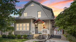 A two-story house with a front porch, a garage, and a well-maintained lawn. - Walk to ND and Eddy Street, ProCleaned * Comfy * Updated (South Bend)