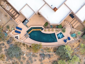 An aerial view of a pool area with a curved pool, lounge chairs, and a staircase leading to an upper level. - Golfers Paradise - Access to ICON Private Gallery and Dove Mountain Golf Club!   (Marana)