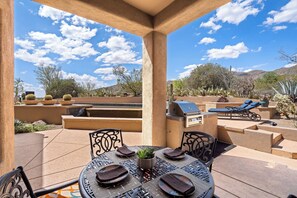 An outdoor patio with a table set for dining, a grill, and lounge chairs. - Golfers Paradise - Access to ICON Private Gallery and Dove Mountain Golf Club!   (Marana)