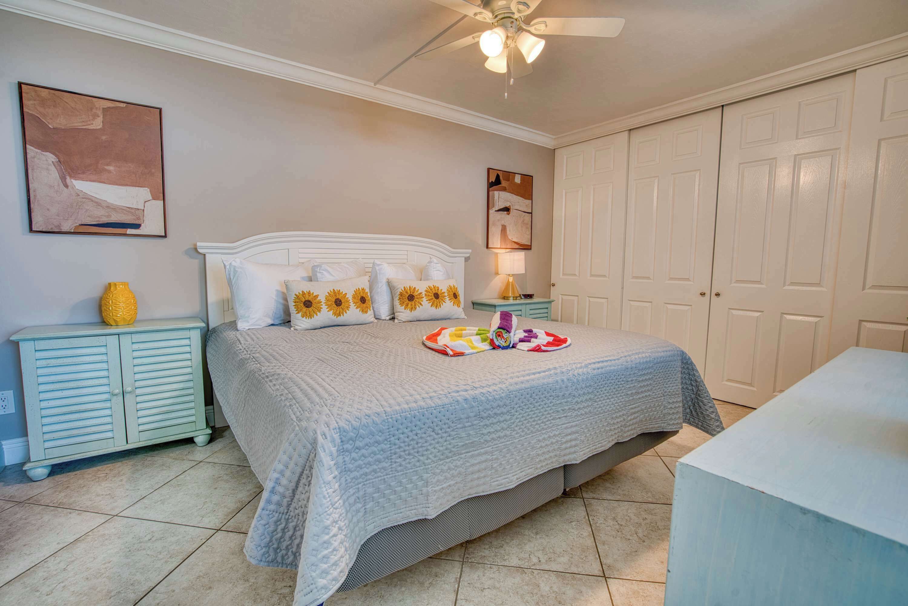 A bedroom with a bed, a nightstand, a lamp, and a wardrobe.