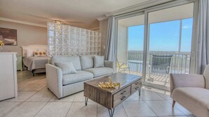 Uma sala de estar moderna com sofá, mesa de centro e varanda com vista.
