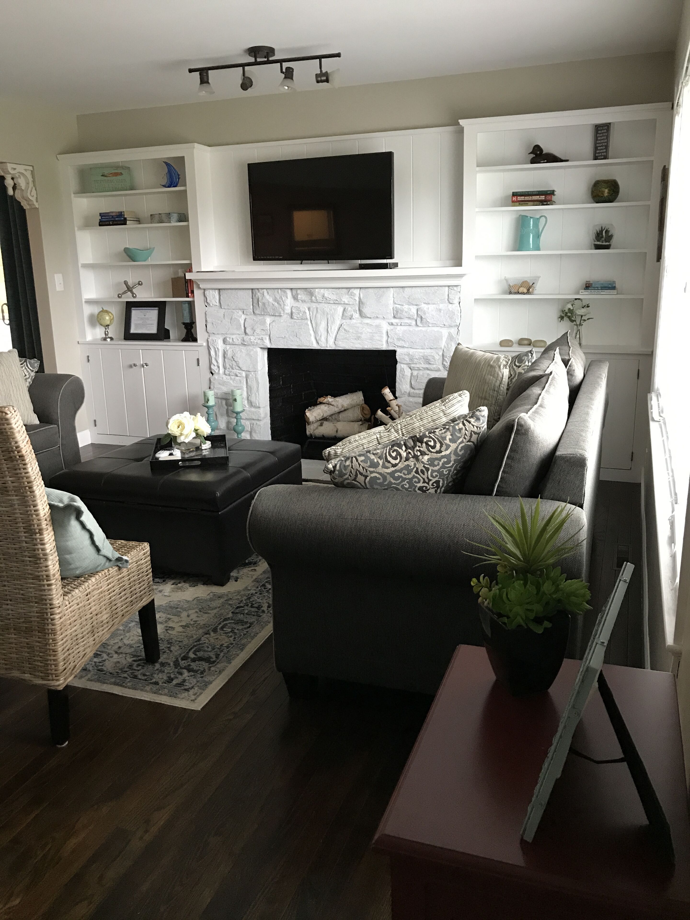 A living room with a fireplace, a television, and a bookshelf.