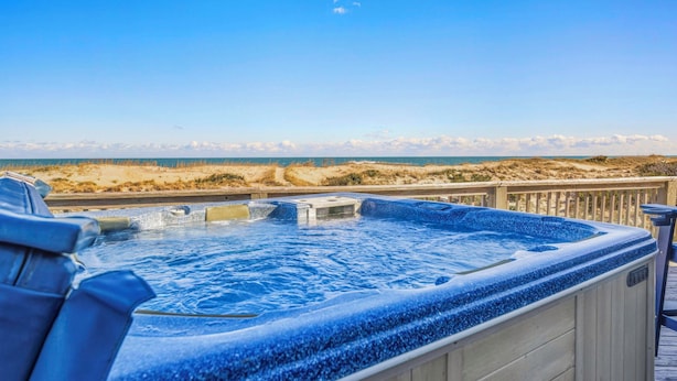 A hot tub with a wooden deck and a view of the beach and ocean. - Oceanfront Bella Beach Box - Dog Friendly w/ Hot Tub and Direct Beach Access (Avon)