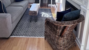 A living room with a sofa, chairs, a coffee table, a fireplace, and a TV.