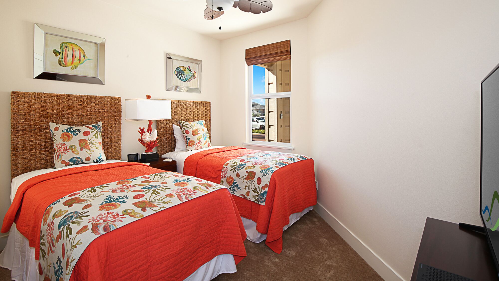 A bedroom with two beds, a large window, and artwork on the walls.
