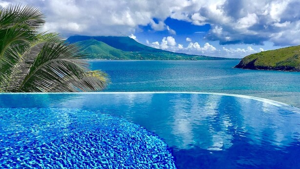 A clear blue pool with a view of a tropical landscape and a mountain in the background. - St Kitts Two for One Luxury Villa & Private Lounge on beach breathtaking views! (South East Peninsula)