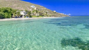 A coastal area with clear turquoise waters, a sandy beach, and buildings on a hillside. - St Kitts Two for One Luxury Villa & Private Lounge on beach breathtaking views! (South East Peninsula)