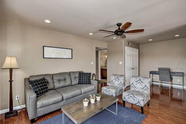 A living room with a grey sofa, patterned armchair, and a coffee table with potted plants. - ON GOLF COURSE & Camelback Mtn Views, Spring Training & Shopping (Scottsdale)