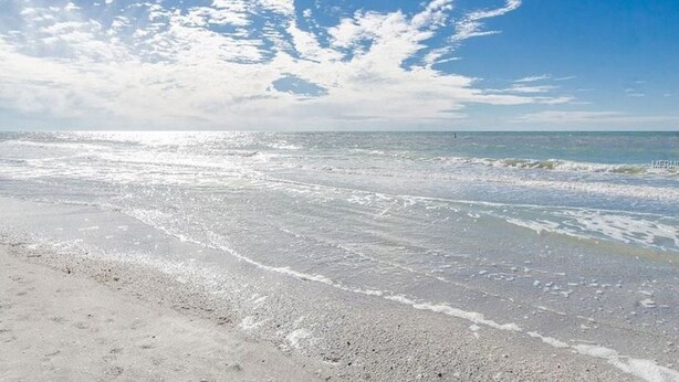 Une plage avec des vagues et un ciel dégagé.