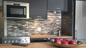 A modern kitchen with a microwave, stove, and a bowl of apples on the counter. - New Basement Private Suite - Fully Furnished,  1 BEDROOM & Futon (Vancouver)