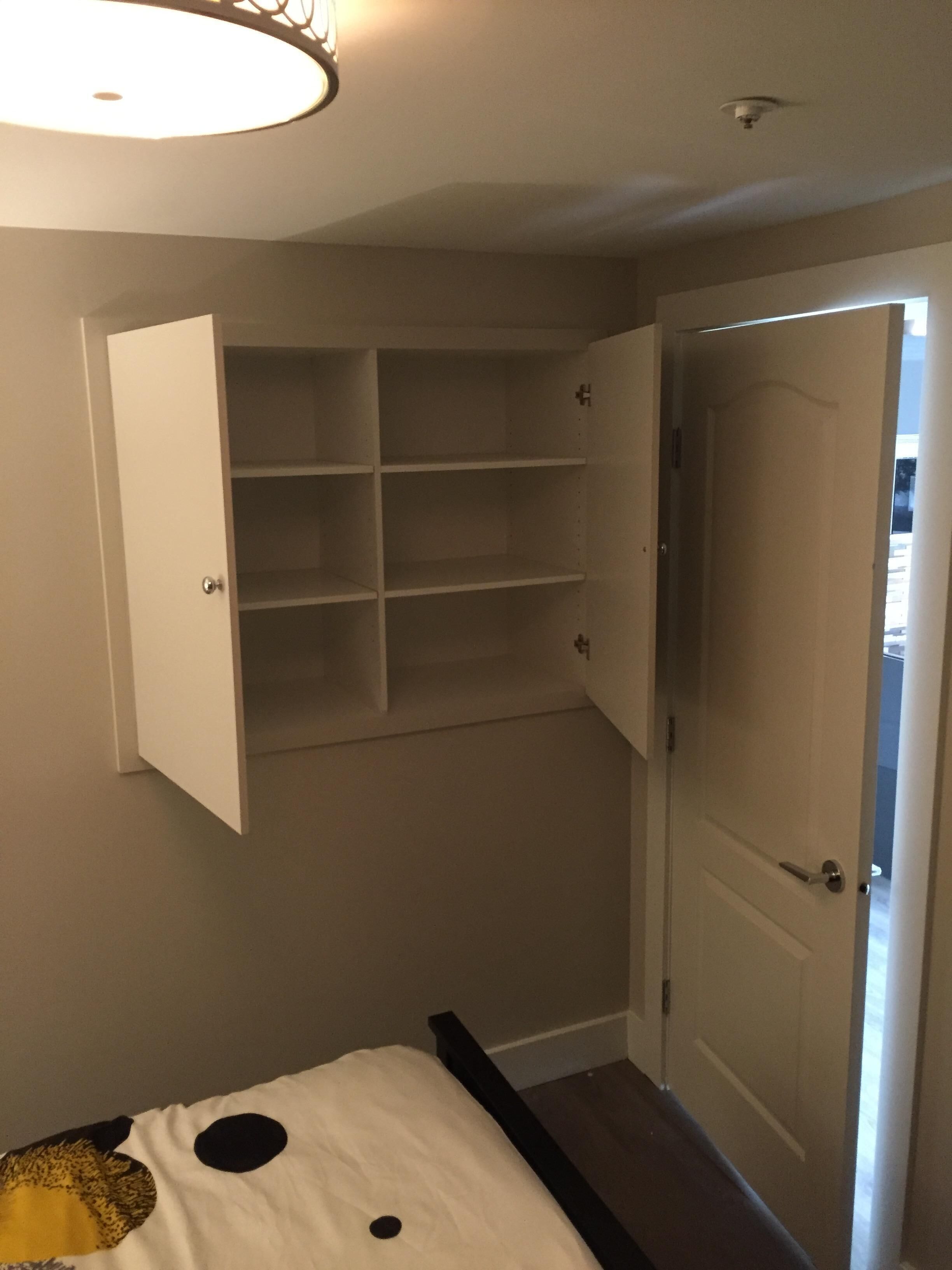 Une chambre à coucher avec un lit, une armoire et une porte.