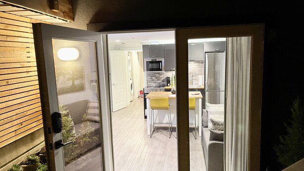 An open sliding glass door leading to a modern kitchen with a dining area. - New Basement Private Suite - Fully Furnished,  1 BEDROOM & Futon (Vancouver)
