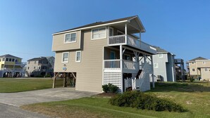 A two-story residential building with a balcony and a garage. - 4 Bedroom, 2.5 bath, sleeps 10, 1 block to beach with beach access and Hot Tub! (Nags Head)