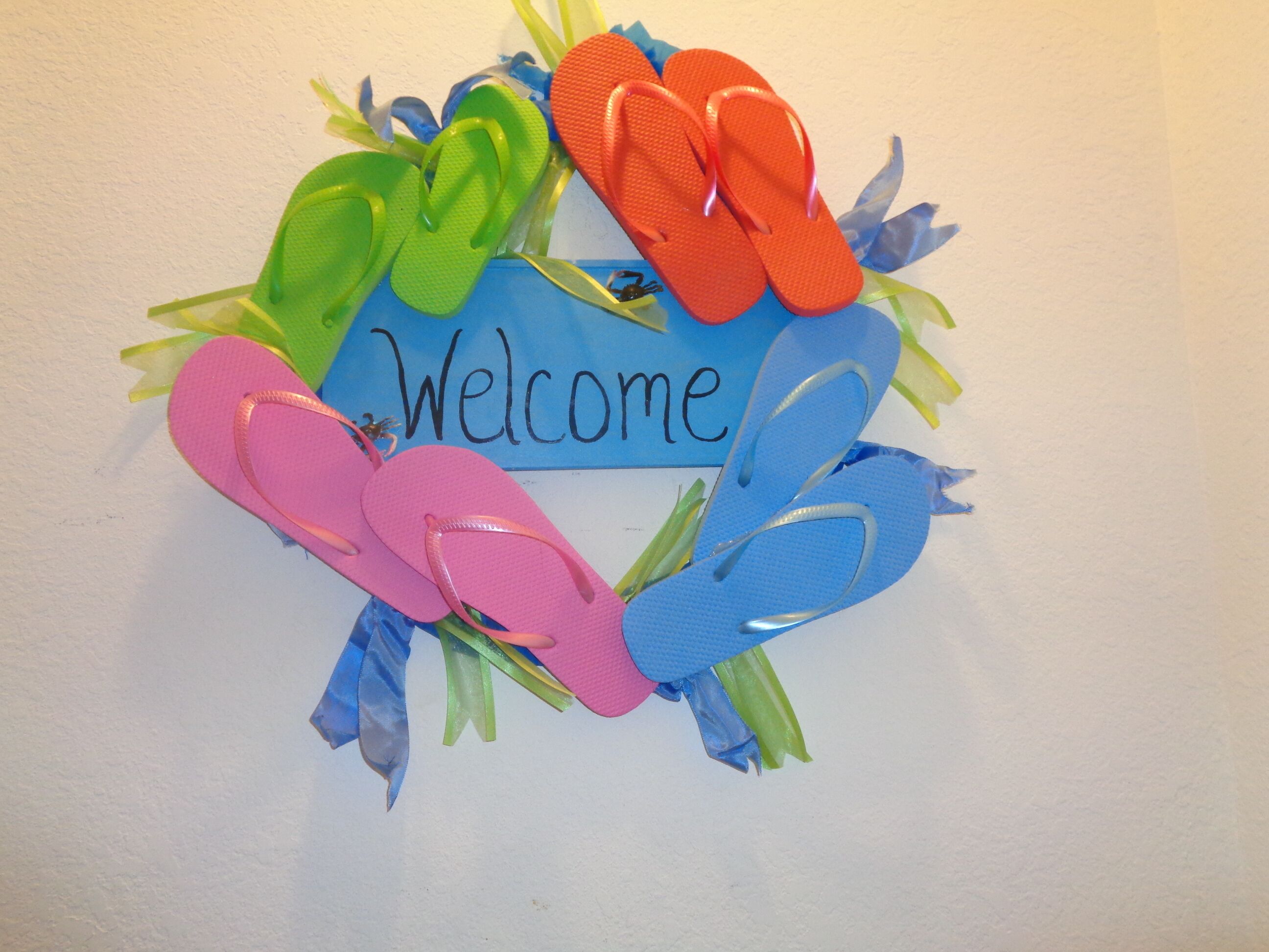 A welcome sign with flip-flops and ribbons.