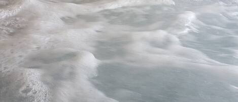 A hot tub with visible bubbles and a drain.
