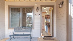 A wooden porch with a bench, a door marked "CH4", and a welcome mat.