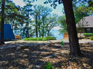 A lakeside cabin with a deck and a view of the water.
