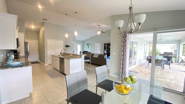 A modern kitchen with a dining area, a large island, and a view of the backyard.