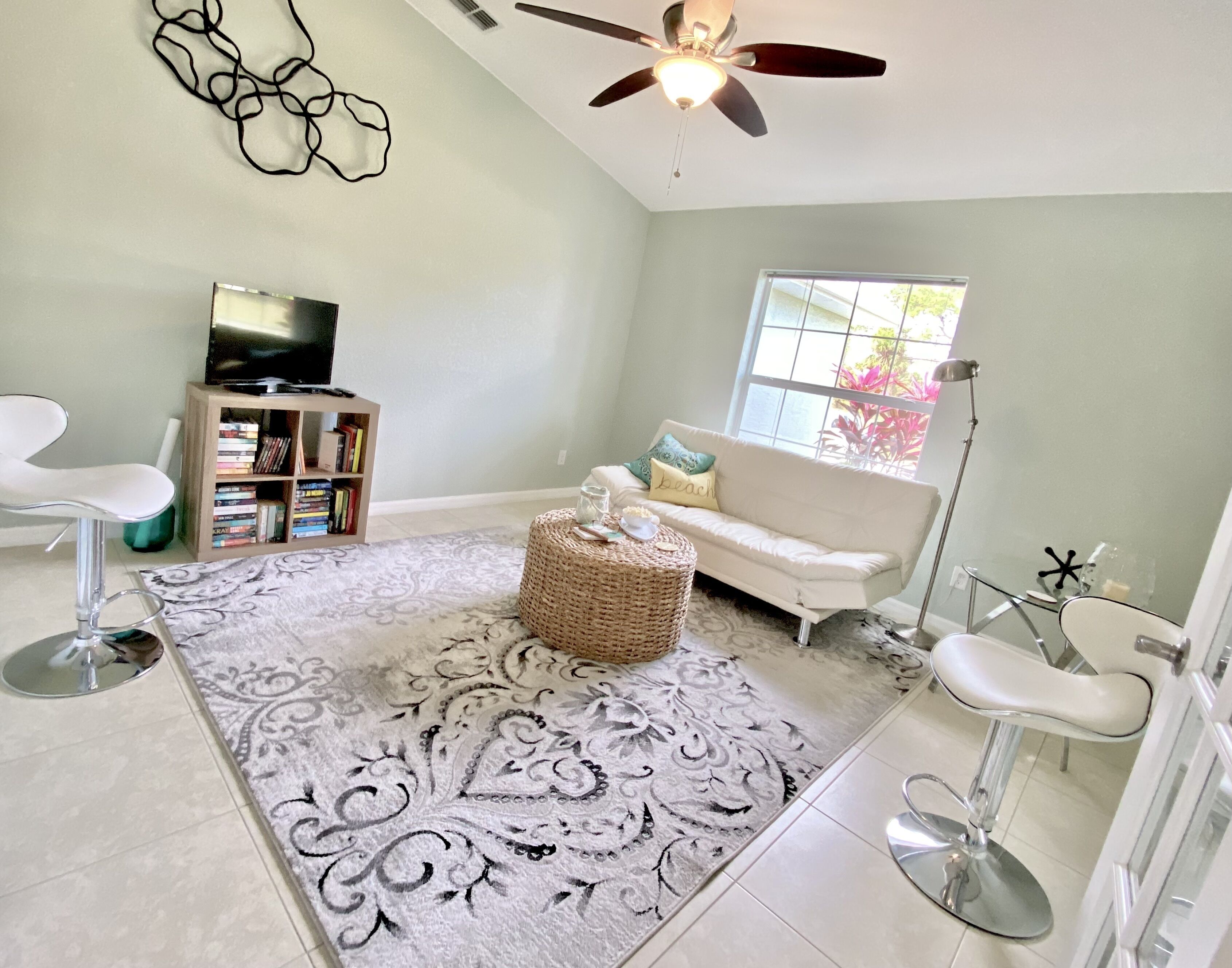 A living room with a television, bookshelves, a sofa, a coffee table, and a floor lamp.