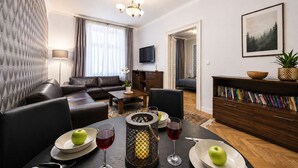 Ein modernes Wohnzimmer mit einer Couch, einem Esstisch und einem Bücherregal.