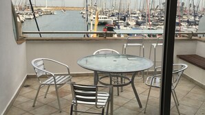 A balcony with a glass table and chairs, overlooking a marina with numerous sailboats. - 0cean front Herzelia condo next to beach and resturants (Herzliya)