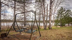 A swing set in a wooded area with a lake in the background. - Private Lodge on Private Lake, Embarrass MN. Boat & Motor Cable WiFi Internet  (Embarrass)