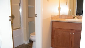 Une salle de bain avec des toilettes, un lavabo et un miroir.