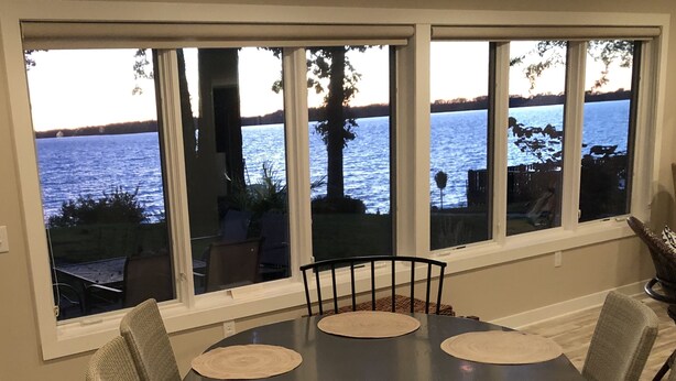Ein Essbereich mit Seeblick, ein Tisch mit Platzsets und Stühle.