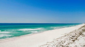 Une plage à l’eau turquoise et au sable blanc.