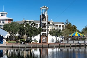 A waterfront hotel with a prominent tower, a carousel, and a sign for 'Zone 1'.