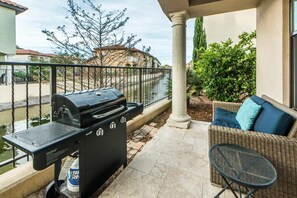 Un patio con parrilla, mobiliario exterior y vistas a un río.